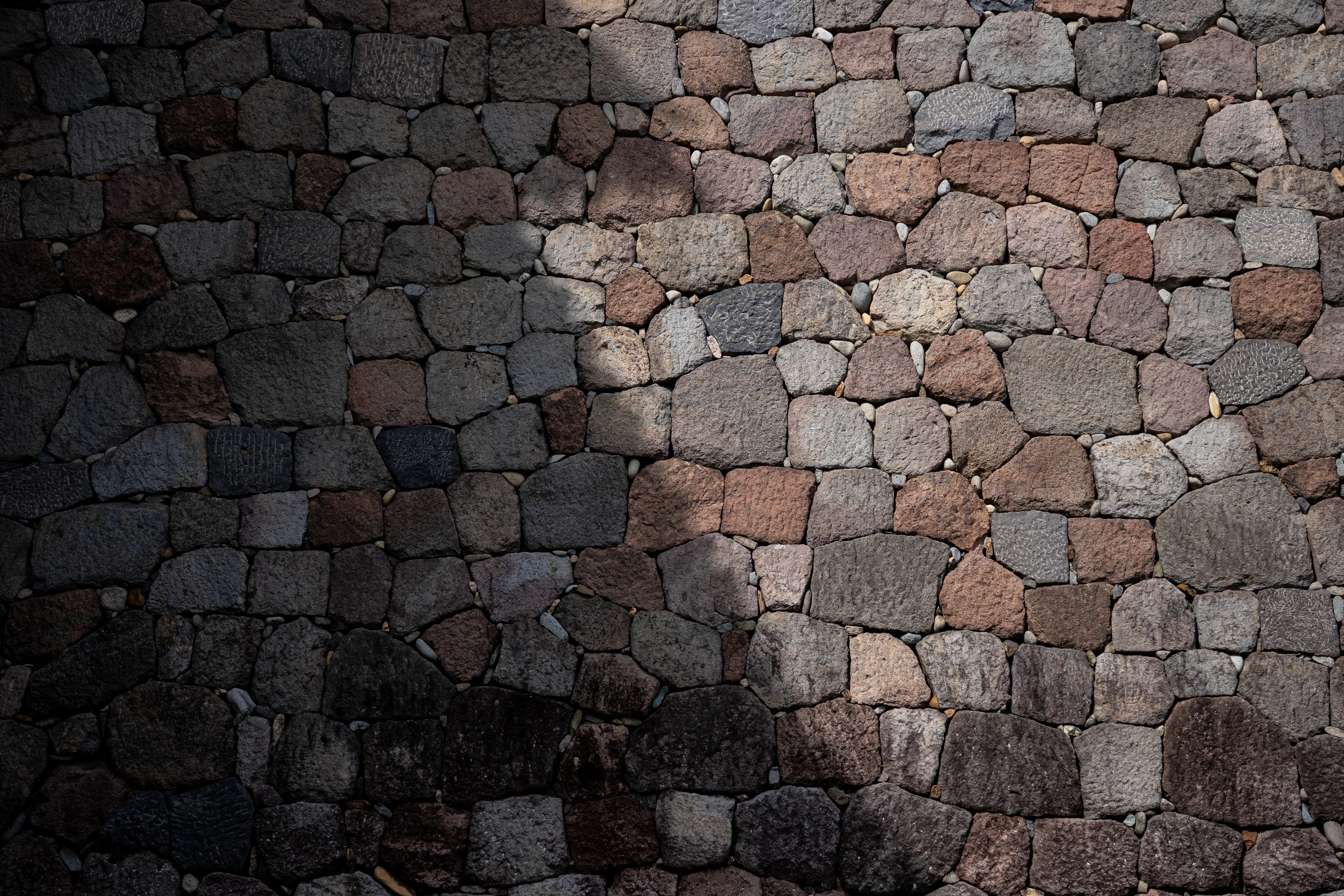 Shadow and light across a stone wall