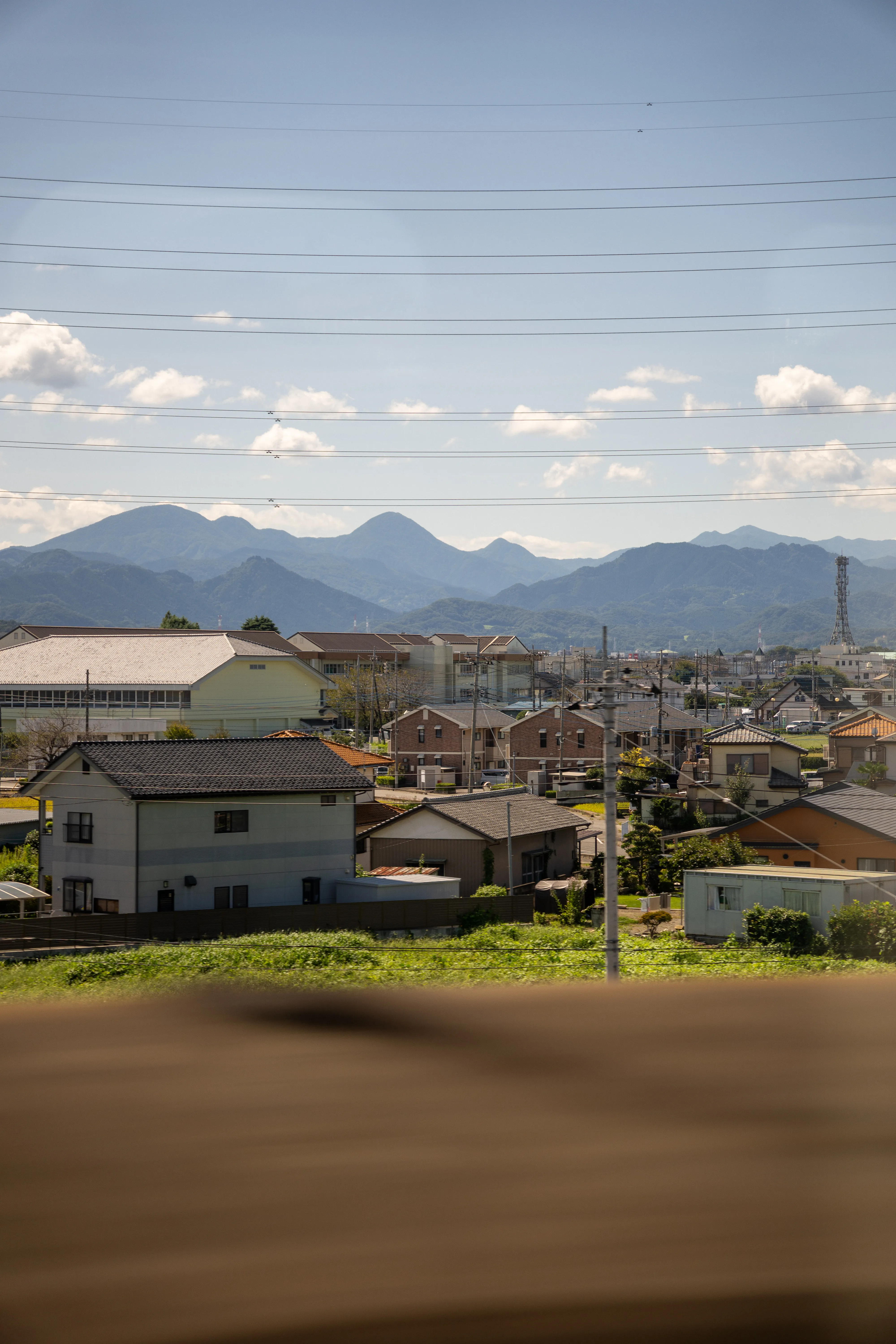 A Japanese town with mountains seen from a shinkansen